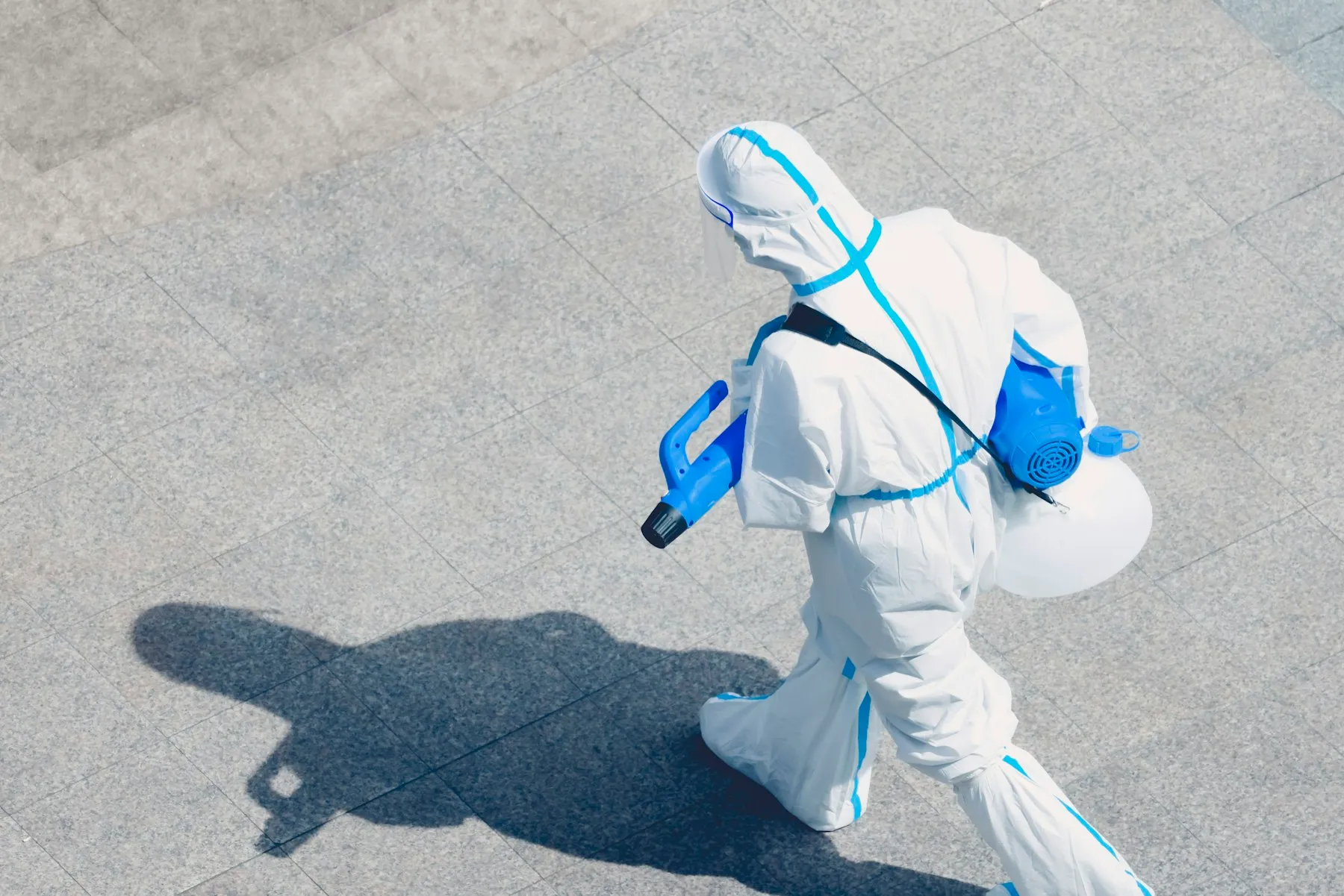 Técnico con traje de protección aplicando un tratamiento de fumigación