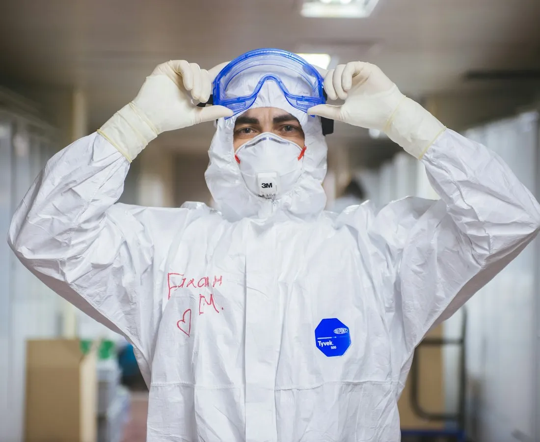 Técnico con traje de protección, lentes y respirador
